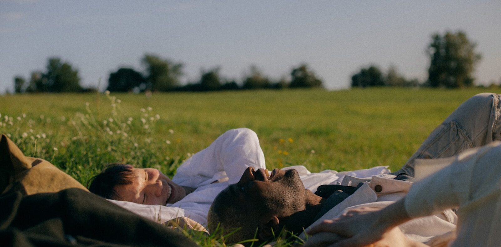 A stock image of people laying in the grass.
